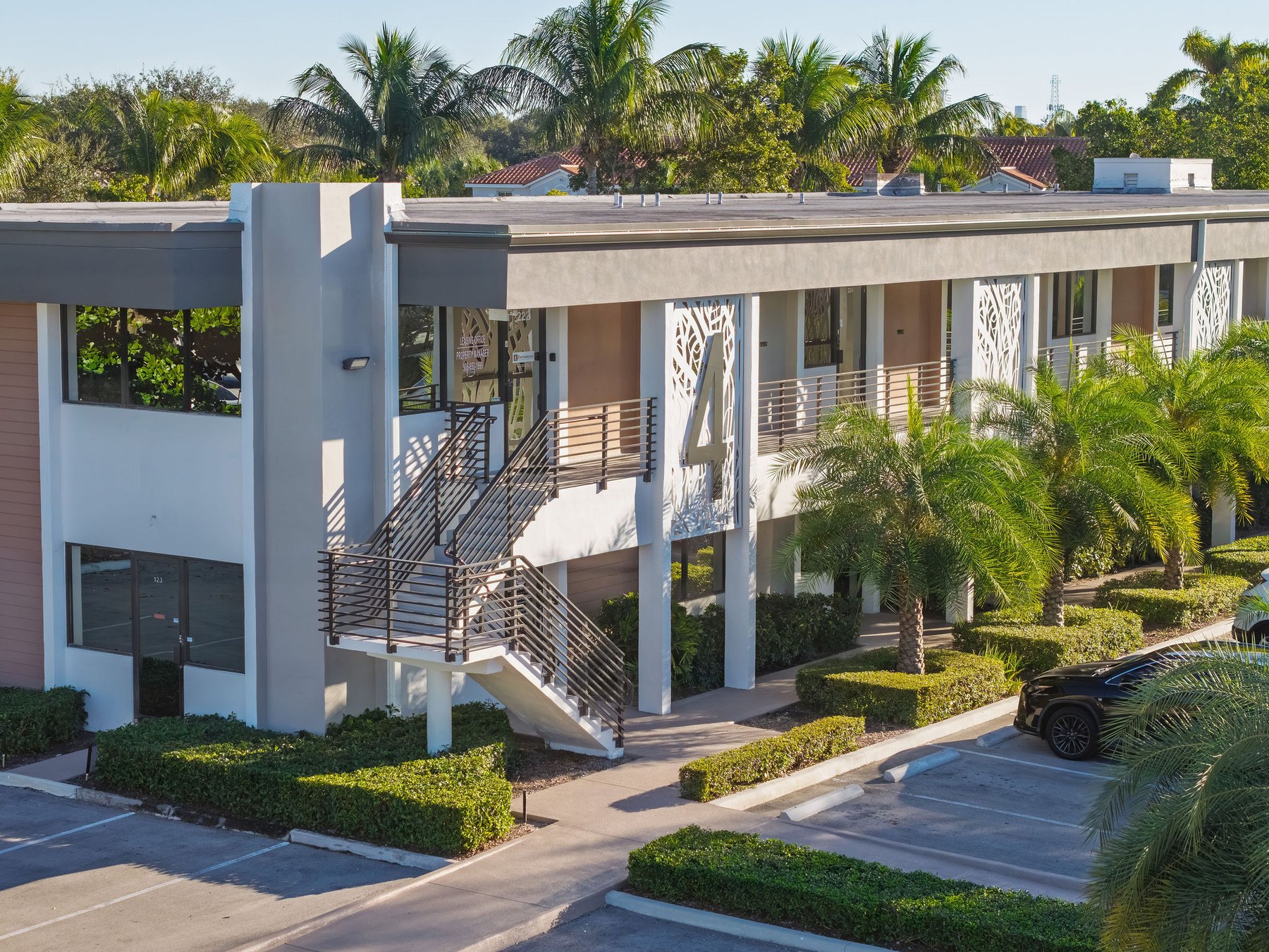 Aerial view of a two-story office building at The Office Park at the California Club, framed by palms and parking
